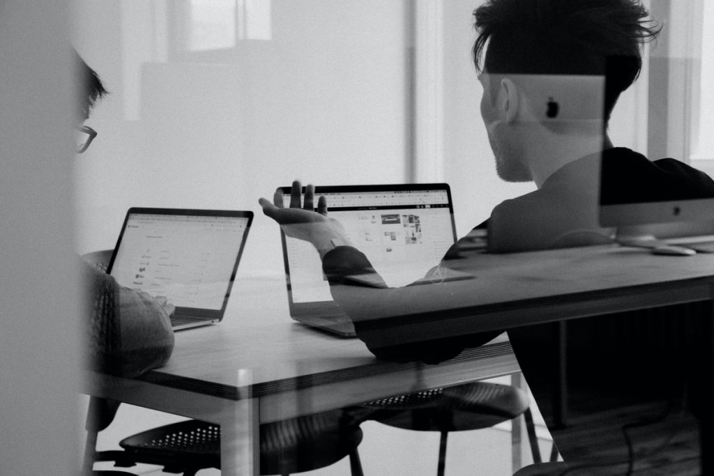 Two people with laptops in a meeting room to illustrate B2B industry.